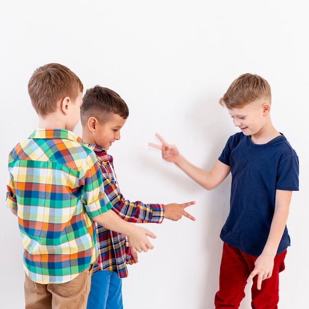 Free photo group of boys playing rock scissors paper game