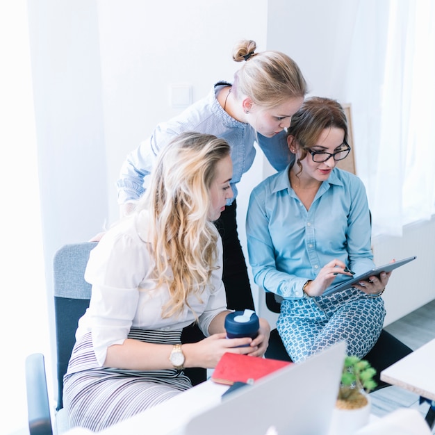 Free Photo group of businesspeople looking at digital tablet in office meeting