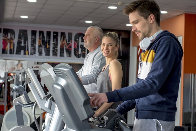 Free Photo group of caucasian friends exercising together on treadmills in a gym