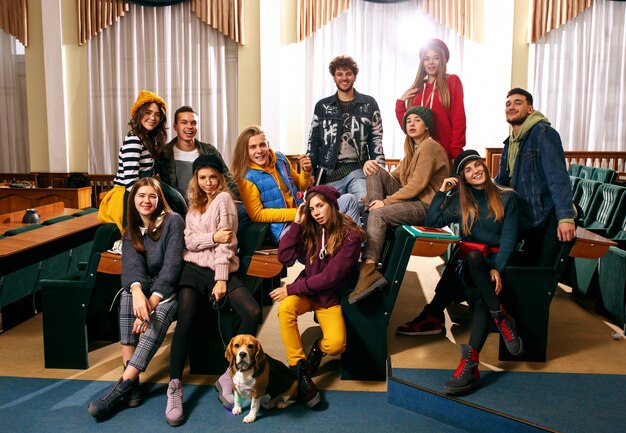 The group of cheerful happy students sitting in a lecture hall before lesson