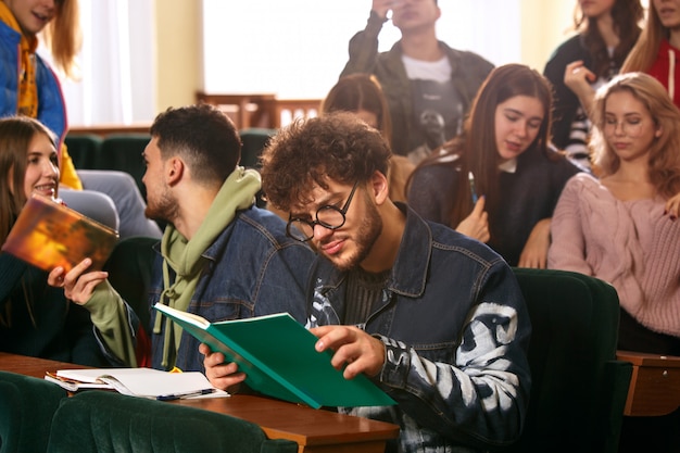 The group of cheerful happy students sitting in a lecture hall before lesson