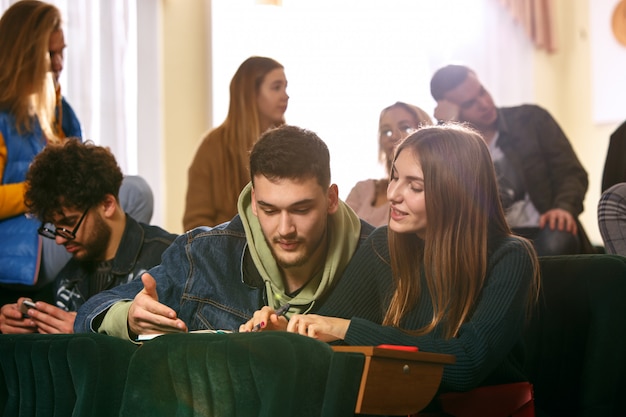 Free photo the group of cheerful happy students sitting in a lecture hall before lesson