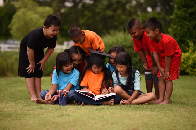 Group of children lying reading on grass field