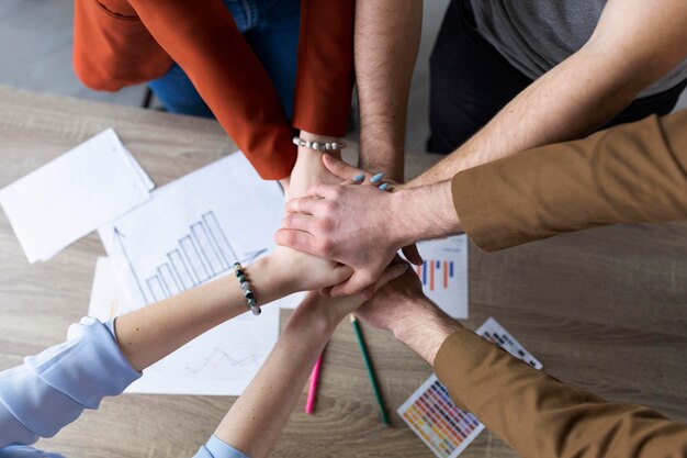 Group of coworkers putting their hands together