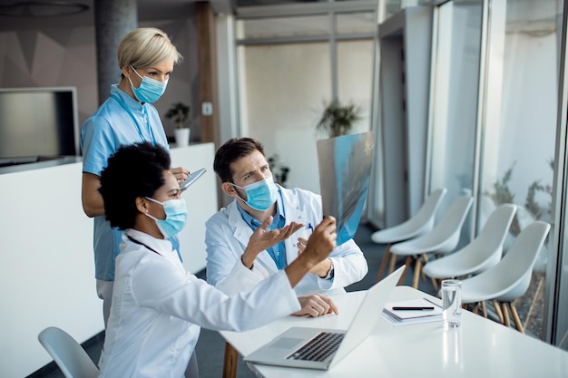 Free Photo group of doctors cooperating while examining xray of a patient at the hopital