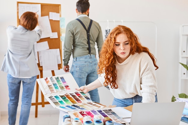 Group of fashion designer working in atelier with color palette and idea board