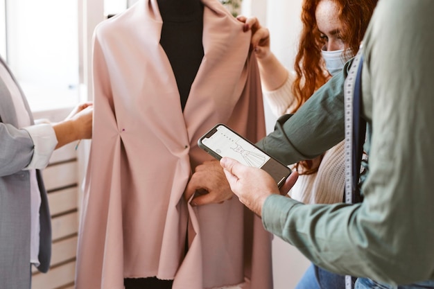 Free photo group of fashion designers working in atelier and checking garment on dress form