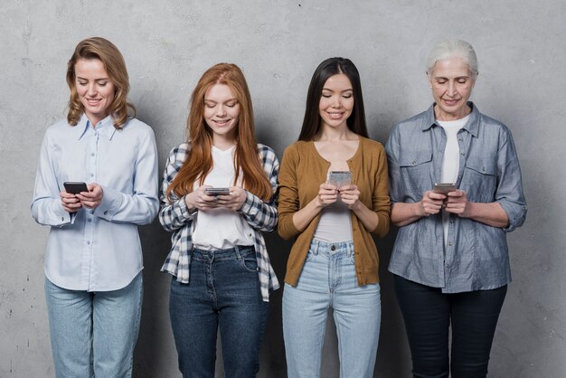 Group of female friends texting on phones