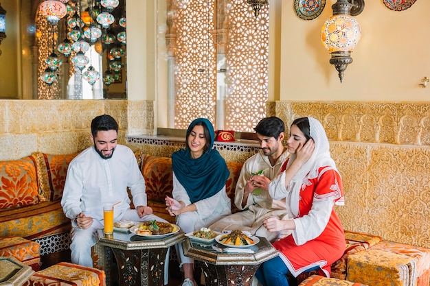 Group of four muslim friends in restaurant