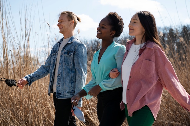 Free photo group of friends celebrating the lifting of face mask restrictions outdoors