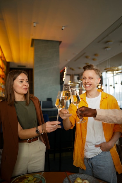 Group of friends cheering with wine glasses at a restaurant