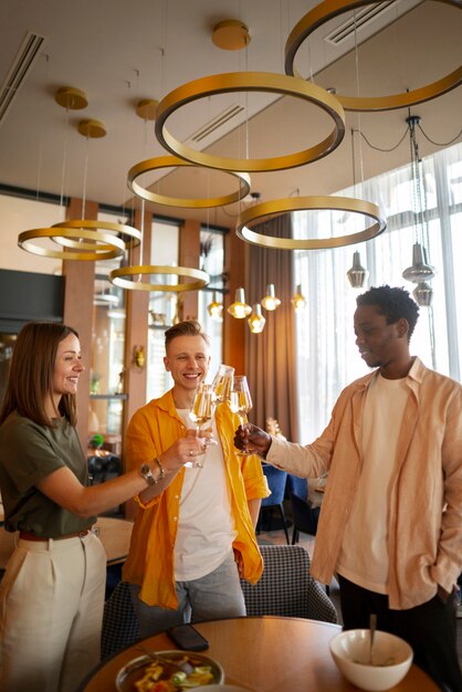 Group of friends cheering with wine glasses at a restaurant