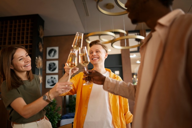 Free Photo group of friends cheering with wine glasses at a restaurant