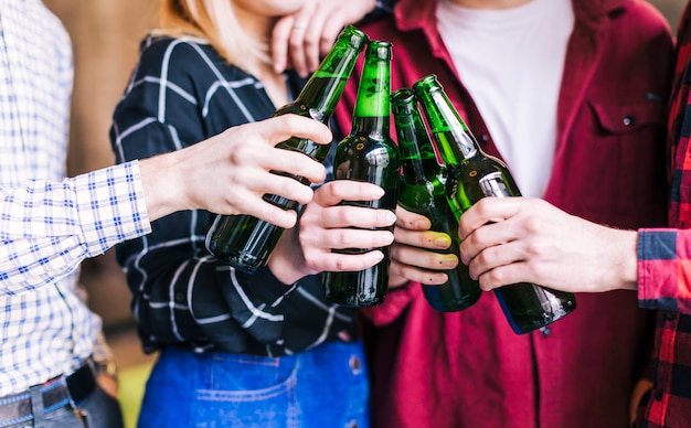 Free photo group of friends clinking bottles of beer