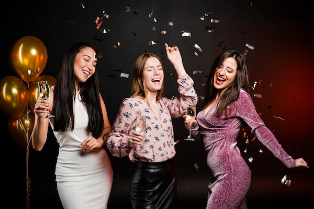 Group of friends dancing surrounded by confetti