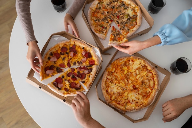 Free photo group of friends eating pizza at home together