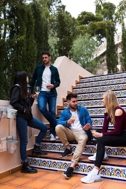 Group of friends enjoying drinks on staircase