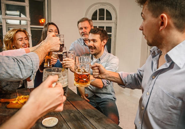 Free photo group of friends enjoying evening drinks with beer