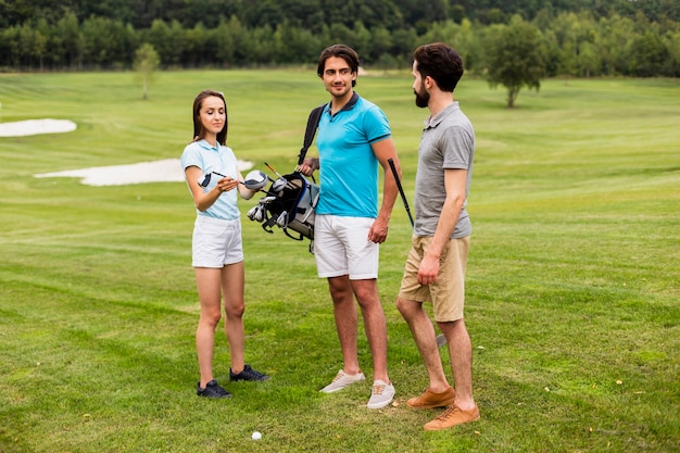 Free photo group of friends having fun on golf course