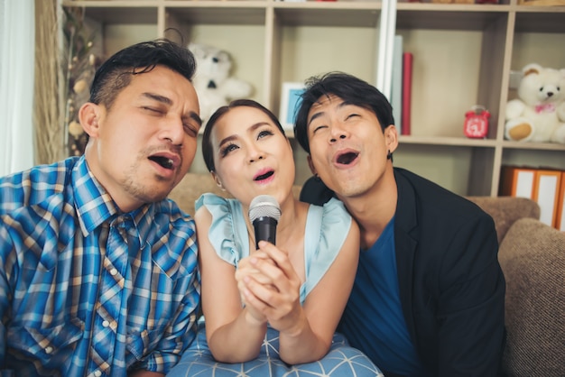 Group of friends having fun at living room singing a song together