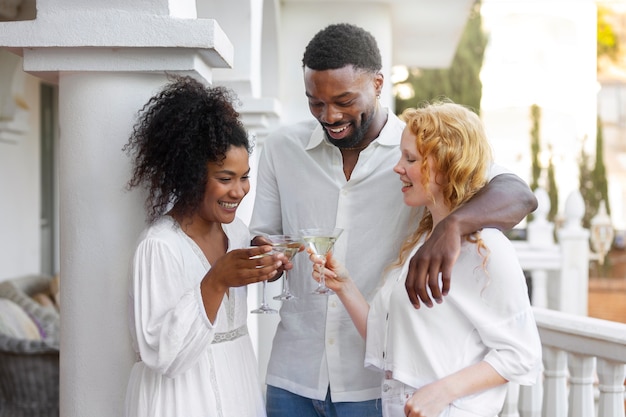 Group of friends having fun during a white party with drinks