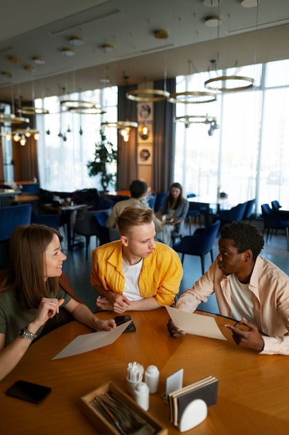 Free photo group of friends looking at the menu together at restaurant