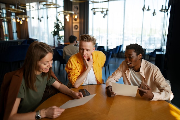 Free Photo group of friends looking at the menu together at restaurant