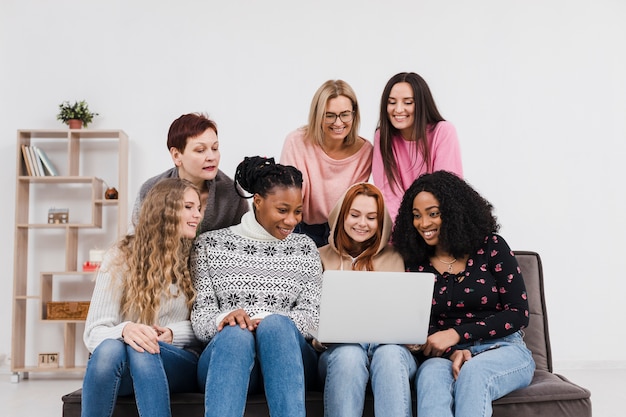 Free photo group of friends looking through a laptop