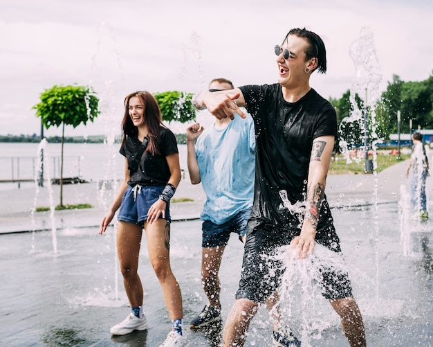 Group of friends making fun in the fountain