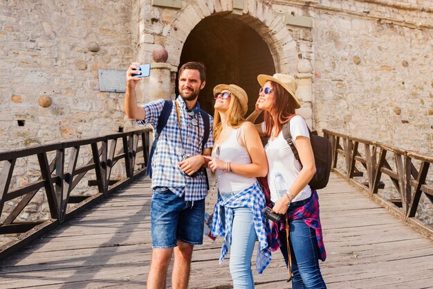 Group of friends taking selfie on cellphone