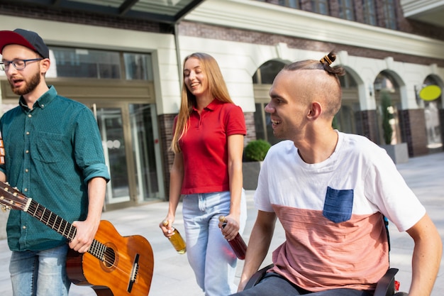 Group of friends taking a stroll on city's street in summer day