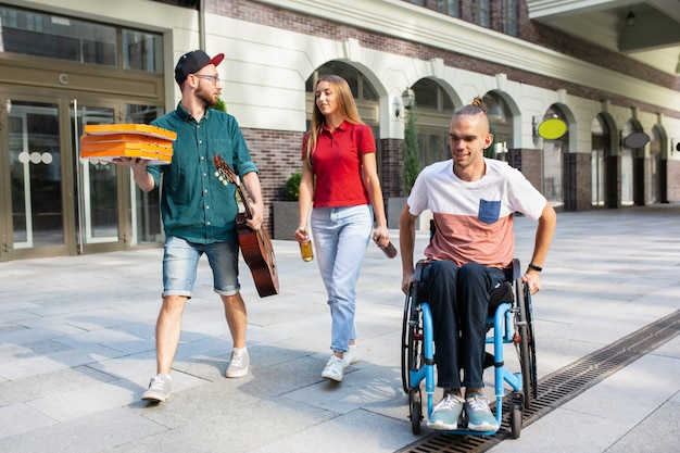 Free Photo group of friends taking a stroll on city's street in summer day