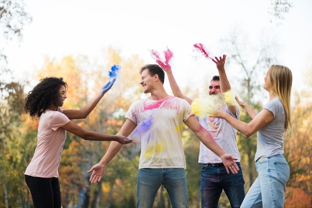 Group of friends throwing powdered color in the air