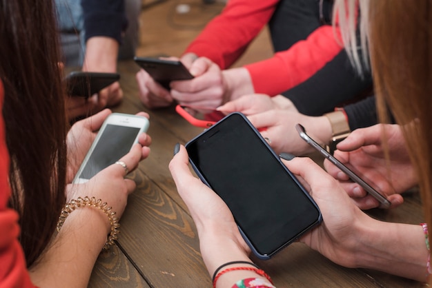 Group of friends using smartphones