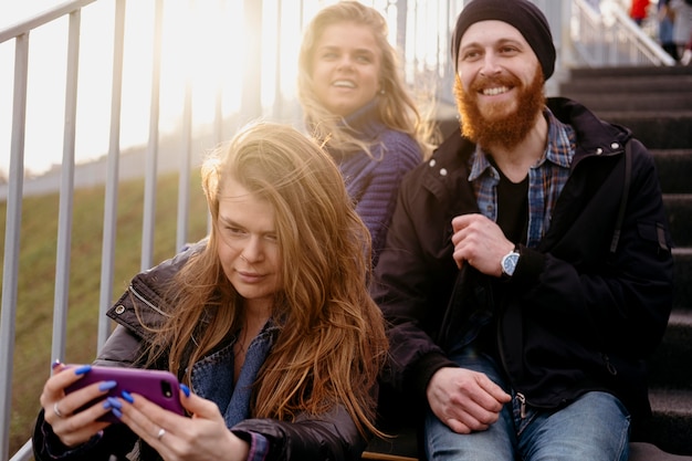 Free photo group of friends with smartphone on stairs