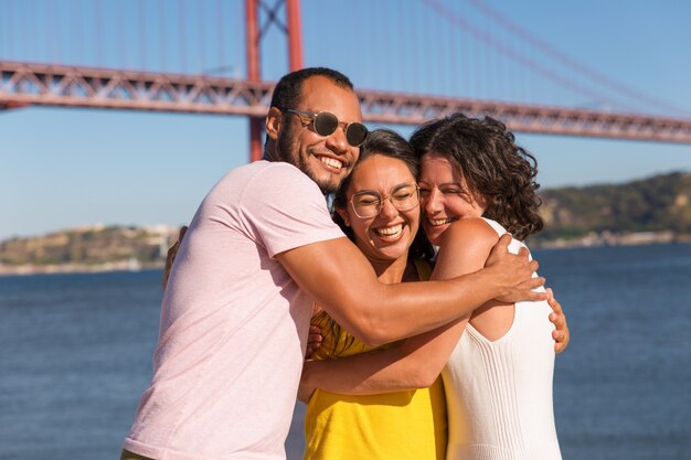 Group of happy close friends greeting and embracing each other