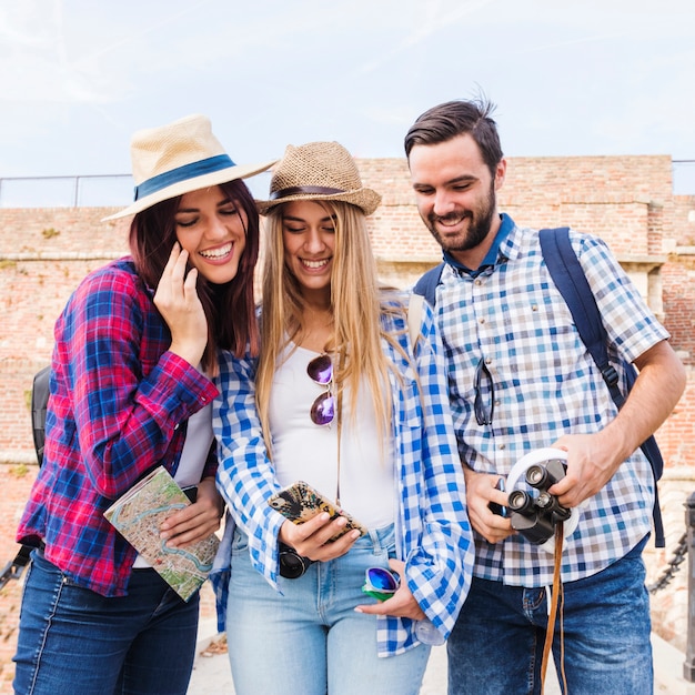 Group of happy friends looking at cellphone