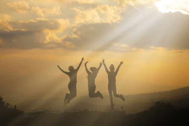 Free photo group of happy people playing at summer sunset in nature