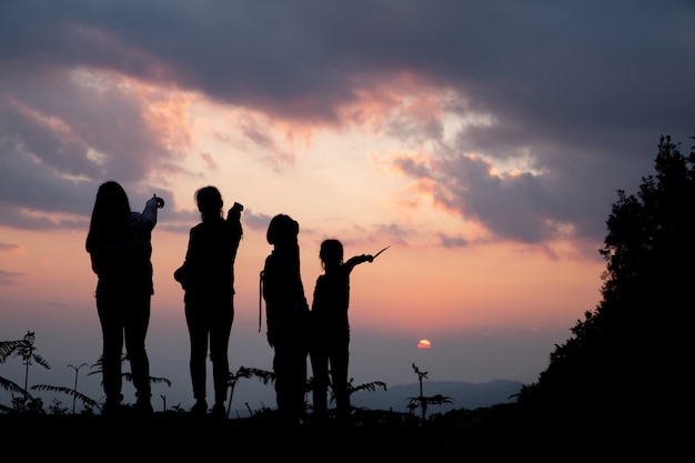 Free photo group of happy people playing at summer sunset in nature