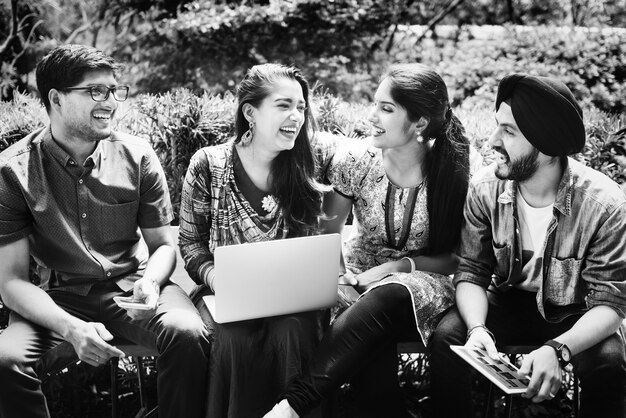 Group of happy young Indian adults using laptop