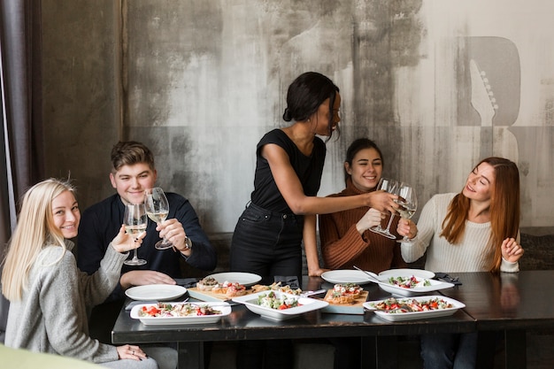 Free photo group of happy young people enjoying dinner