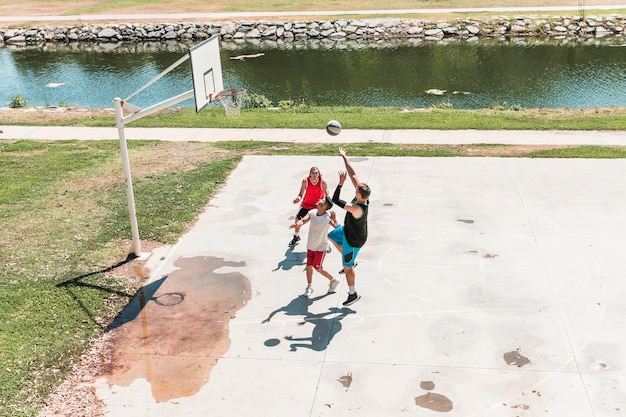 Free photo group of male player playing basketball at outdoors court