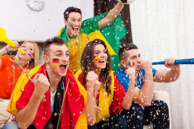 Group of multi-ethnic people celebrates win of favourite football team