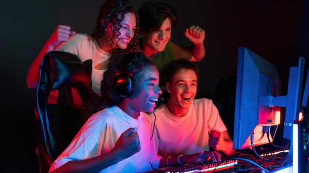 Free Photo group of multiracial teens playing video games in video game club with blue and red illumination excited because of a victory