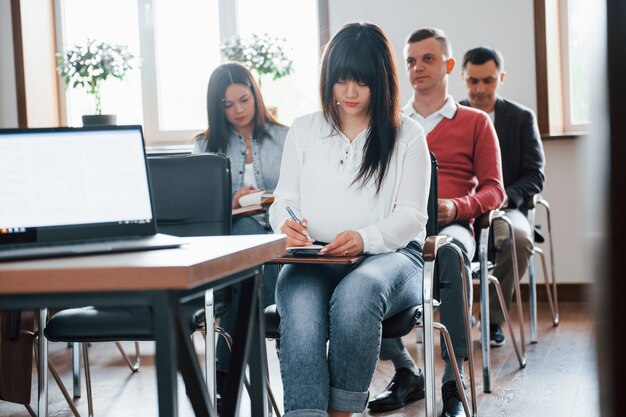 Group of people at business conference in modern classroom at daytime