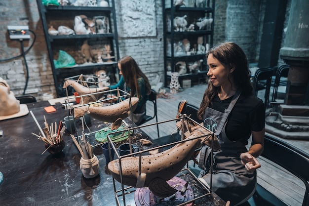 Free Photo group of people enjoying favorite job in workshop. people carefully work on ceramic whales