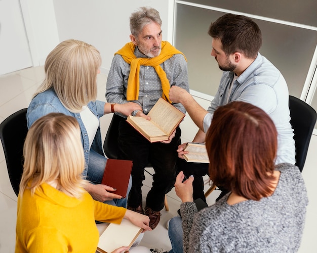 Free photo group of people reading books at therapy session