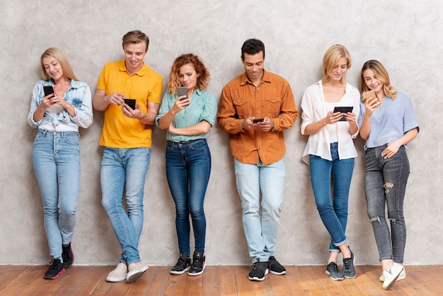 Group of people standing and checking devices