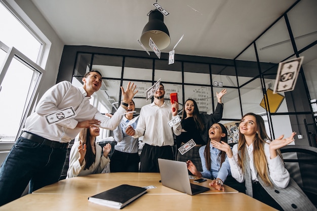 Free photo group of people throwing money in an office