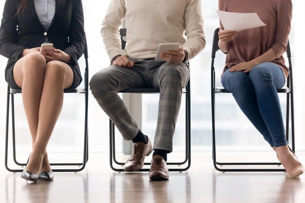 Group of people waiting for job interview, sitting on chairs